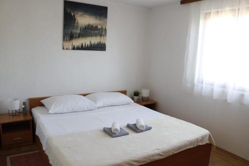 sypialnia z łóżkiem i dwoma ręcznikami na nim w obiekcie Holiday Home Maslina w mieście Stankovci
