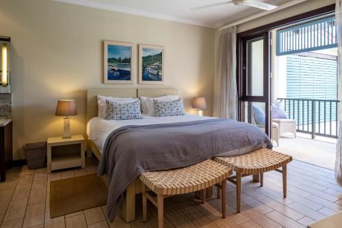 a bedroom with a large bed and a balcony at Maison L'Amirale by Simply-Seychelles in Eden Island