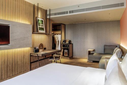 a hotel room with a bed and a couch at The Botanica Sanctuary in Puncak
