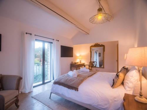 une chambre avec un grand lit et une grande fenêtre dans l'établissement Le Mas Fanny Intimate version, à Gordes