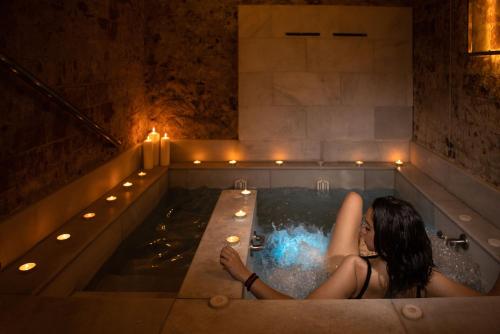 a woman laying in a bath tub with lights at RVHotels Broquetas Spa Termal in Caldes de Montbui