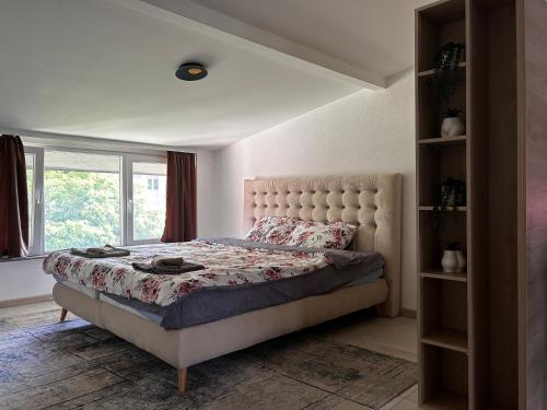 a bedroom with a large bed with a large window at Anton Lux Apartment in Kochani