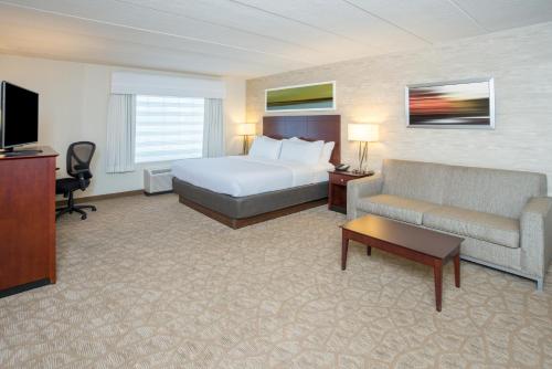 um quarto de hotel com uma cama e um sofá em Holiday Inn Baltimore BWI Airport, an IHG Hotel em Linthicum Heights