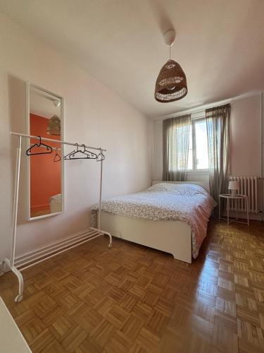une chambre avec un lit et un miroir dans l'établissement Appartement 3 chambres, à Rennes