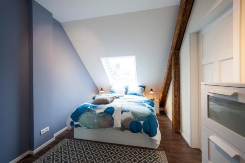 a bedroom with a bed in a blue room at Apartments LUDGERUSHOF in Bocholt