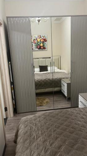 a reflection of a bedroom with a bed and a mirror at Mont Blanc Art apartments in Yerevan