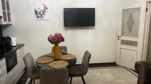 a dining room with a table and chairs and a television at Mont Blanc Art apartments in Yerevan