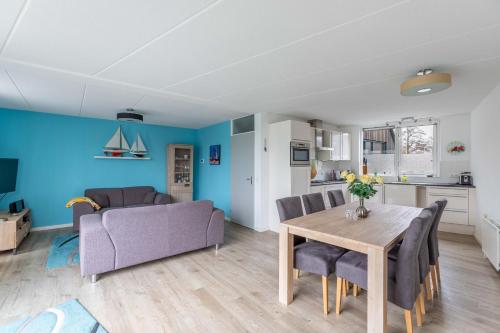 a living room with a table and a couch at Luxe vakantiehuis aan het water, Lemmer in Lemmer