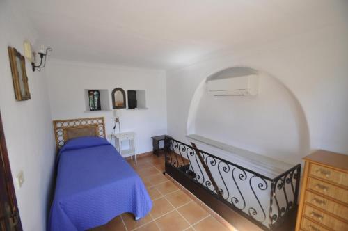 a bedroom with a bed with a blue comforter at Villa Eva in Anacapri