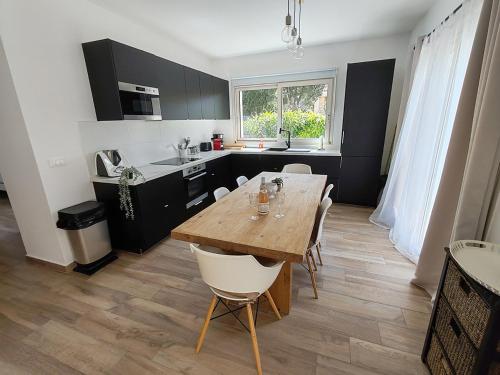 een keuken met een houten tafel en stoelen in een kamer bij Appartement 80 m2 avec jardin - 50m de la plage TIKI in Saint-Raphaël