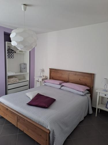 een slaapkamer met een groot bed met roze kussens bij House Al Noce in Moltrasio