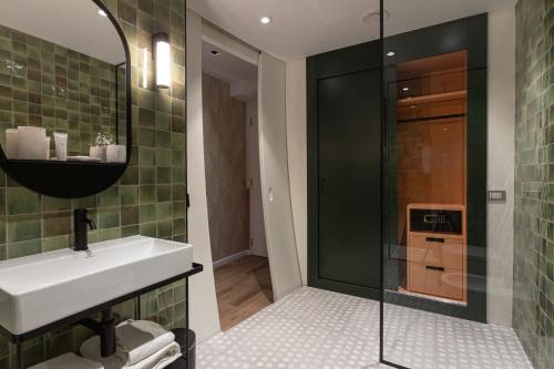 a bathroom with a sink and a glass shower at DuoMo Hotel in Rimini