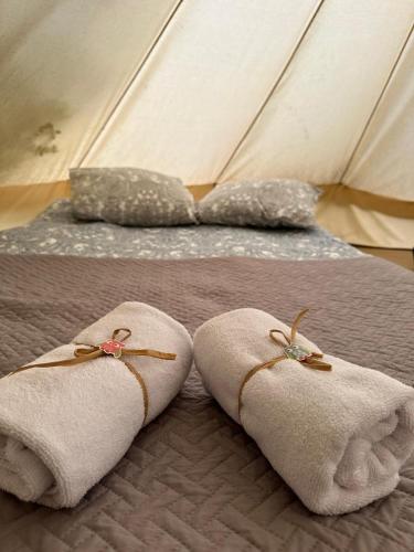 a pair of towels on a bed in a tent at Glamping Cisnadioara in Cisnădioara