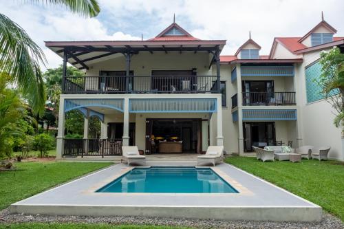 una casa con piscina frente a ella en Maison L'Amirale by Simply-Seychelles, en Eden Island