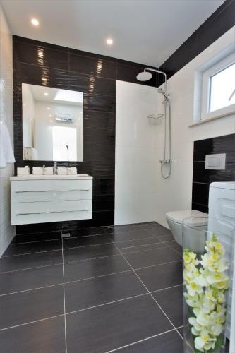 a bathroom with a white sink and a mirror at Villa Lokanjac with pool and panoramic sea view in Selca