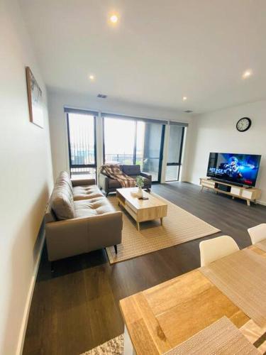 a living room with a couch and a tv at Modern oasis in Rockbank