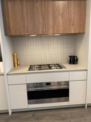 a white kitchen with a stove top oven at Modern oasis in Rockbank