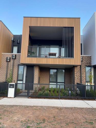 a brick building with a balcony and a fence at Modern oasis in Rockbank