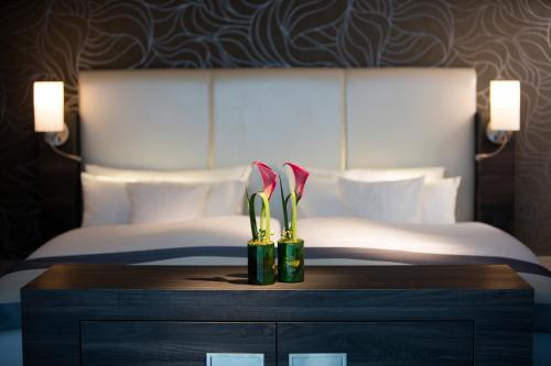 a hotel room with a bed and a table with two awards at Vital Hotel Rhein Main Therme Wellness Resort & SPA in Hofheim am Taunus