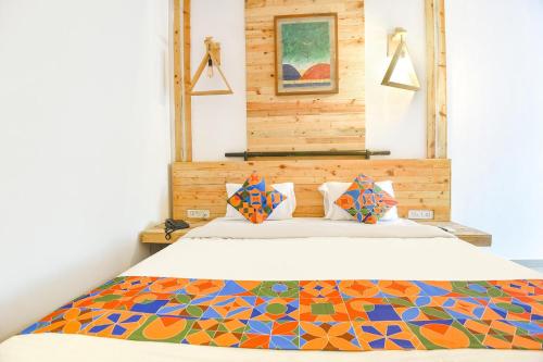 a bedroom with a bed with a colorful comforter at FabExpress Neo Calangute Beach Resort in Calangute