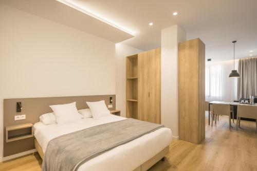 a bedroom with a large bed and a dining room at Mon Suites Jardín de Ayora in Valencia