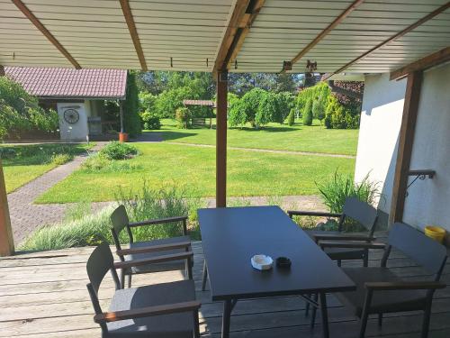 un patio con tavolo e sedie e vista su un cortile di Nakvynės namai šalia Klaipėdos a Klaipėda