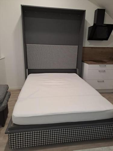 Ce lit se trouve dans un dortoir doté d'un matelas blanc. dans l'établissement studio 24 m² proche arrêt de bus, à Beauvais