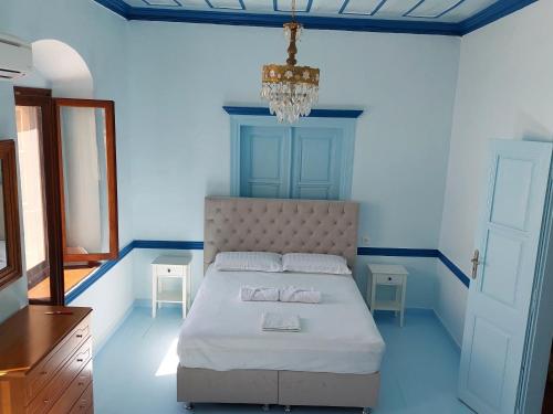 a bedroom with a bed and a chandelier at Villa Pavlos in Symi