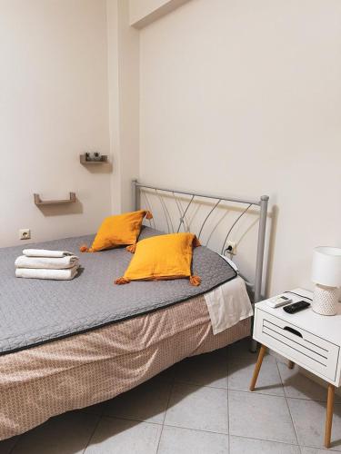 a bed with two yellow pillows on it in a room at Efrosini downtown apartment in Chalkida