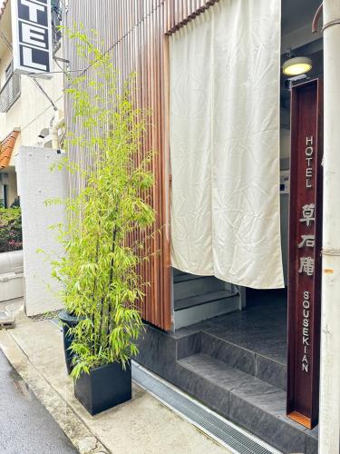 eine auf den Stufen eines Gebäudes sitzende Anlage in der Unterkunft Hotel 草石庵 in Osaka