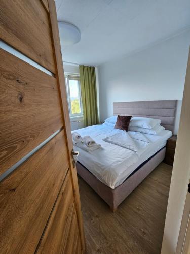 a bedroom with a bed and a wooden door at Apartmán Pohoda in Martin