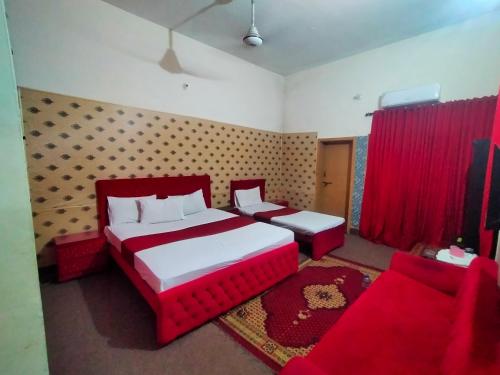 a bedroom with a red bed and a red couch at Peridot Cottage in Islamabad