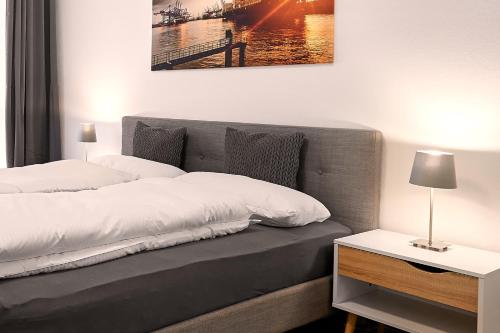 a bedroom with a bed with a lamp on a table at Harbour Prime Apartment Ettlingen Rheinstraße 40 in Ettlingen