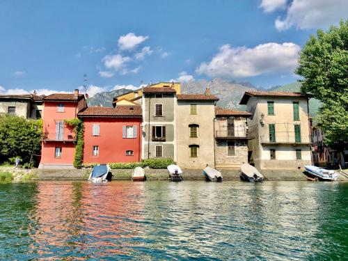 a group of boats in the water in front of buildings at Glamping Camping Rivabella in Lecco