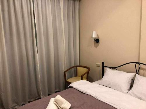 um quarto com uma cama e uma janela com cortinas em Seaside apartments em Batumi