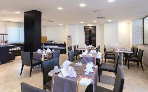 a dining room with tables and chairs in a restaurant at Business Hotel in Tunis