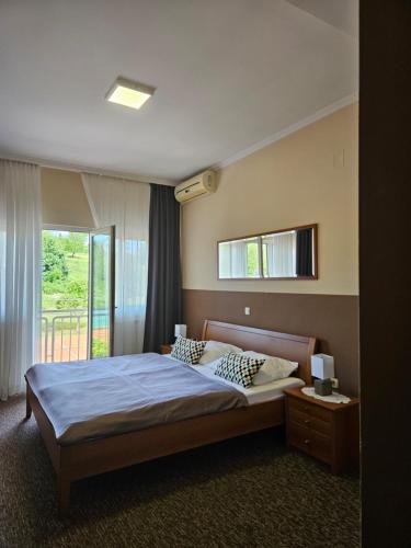 a bedroom with a bed and a large window at Bed and Breakfast Restaurant DP in Donji Zvečaj