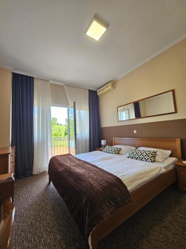 a hotel room with a large bed and a window at Bed and Breakfast Restaurant DP in Donji Zvečaj