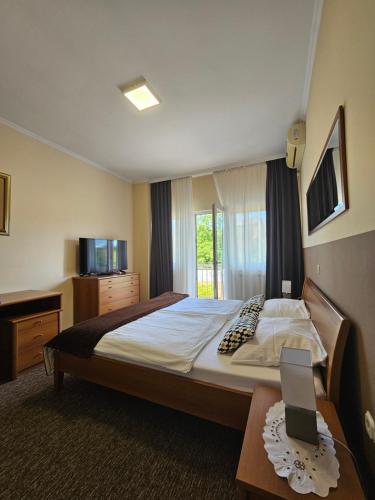 a bedroom with a bed and a table with a tablet on it at Bed and Breakfast Restaurant DP in Donji Zvečaj