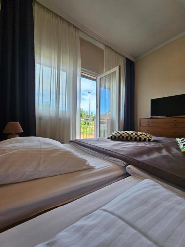 a large bedroom with two beds and a large window at Bed and Breakfast Restaurant DP in Donji Zvečaj