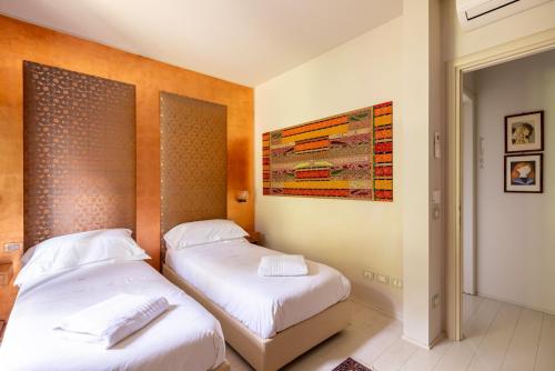 a bedroom with two beds and a painting on the wall at Tenuta Moncarlino in Morsasco