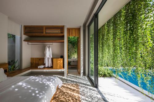 sypialnia z łóżkiem i dużą zieloną ścianą w obiekcie Villa Wyndham Phu Quoc w Duong Dong
