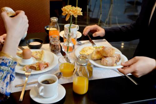 - une table avec des assiettes de petit-déjeuner dans l'établissement Airotel Stratos Vassilikos Hotel, à Athènes