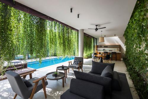 uma sala de estar com piscina e plantas em Villa Wyndham Phu Quoc em Phu Quoc