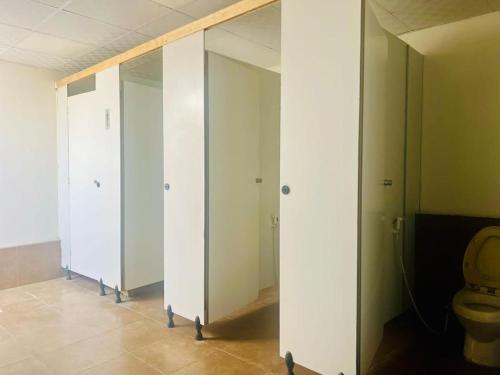 a bathroom with three stalls with a toilet in it at Dubai Tourism and Travel Services in Hunaywah