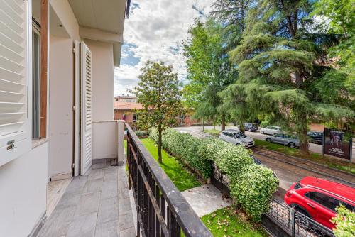 a balcony of a house with a red car on a street at Green House da Fernanda in Empoli