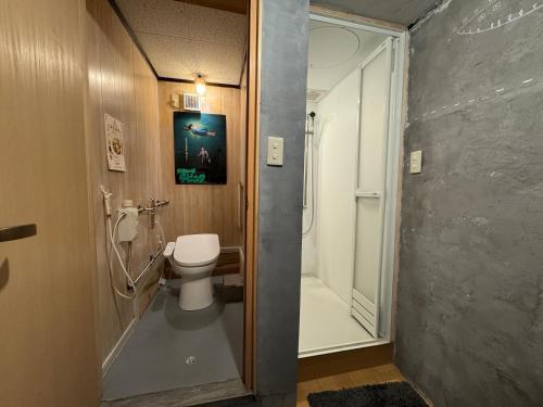 uma casa de banho com um WC e uma cabina de duche ao nível do chão em すくもBOX em Sukumo