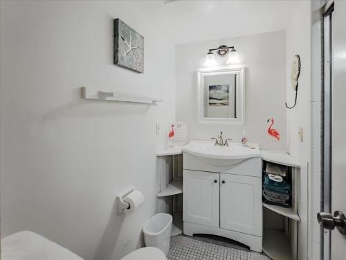 a white bathroom with a sink and a toilet at Beachfront oasis, heated pool and garden view #17 in Marathon