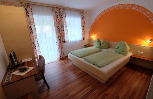 a bedroom with a bed and a table and a desk at Gasthof in der Exlau in Neuhaus