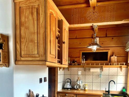 a kitchen with wooden cabinets and a counter top at Mountain cozy house in Tatras in Ząb